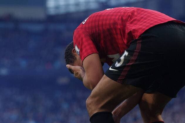 Football - 2012 2013 Premier League - Manchester City vs. Manchester United Rio Ferdinand of Manchester United holds his face after being struck by an object at the Etihad Stadium 
