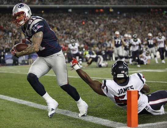 New England Patriots tight end Aaron Hernandez (81) shakes off a tackle by Houston Texans linebacker Bradie James (53) on a seven yard touchdown reception in the first quarter at Gillette Stadium in Foxborough, Massachusetts on December 10, 2012.  BOS2012121009