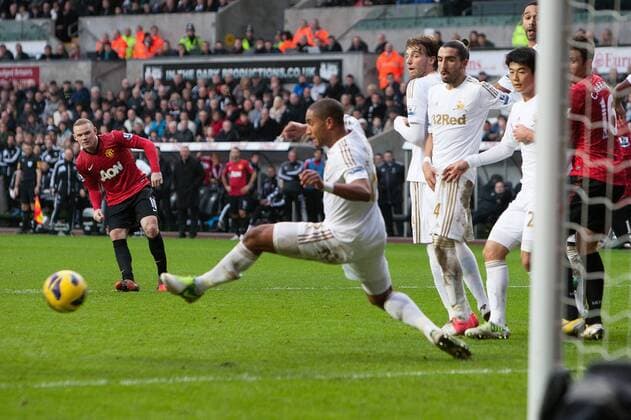 Football - 2012 2013 Premier League - Swansea vs. Manchester United Swansea s Ashley Williams keeps out a free kick from Wayne Rooney of Manchester United at the Liberty Stadium 