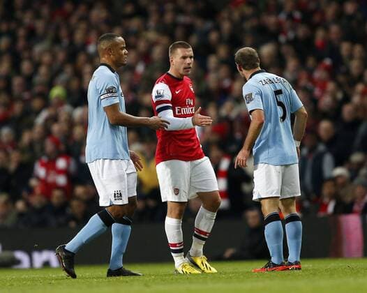 Arsenal s Lukas Podolski is accused of elbowing Manchester City s Pablo Zabaleta, on the left Vincent Kompany. FC Arsenal London vs. Manchester City - Barclays Premier League - Emirates Stadium, London- 13 01 13 EDITORIAL USE ONLY. No use with unauthorised audio, video, data, fixture lists, club league logos or live services. Online in-match use limited to 120 images, no video emulation. No use in betting, games or single club league player publications.