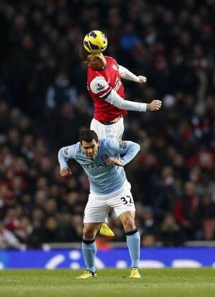 Arsenal s Thomas Vermaelen tussles with Manchester City s Carlos Tevez.. FC Arsenal London vs. Manchester City - Barclays Premier League - Emirates Stadium, London- 13 01 13 EDITORIAL USE ONLY. No use with unauthorised audio, video, data, fixture lists, club league logos or live services. Online in-match use limited to 120 images, no video emulation. No use in betting, games or single club league player publications.