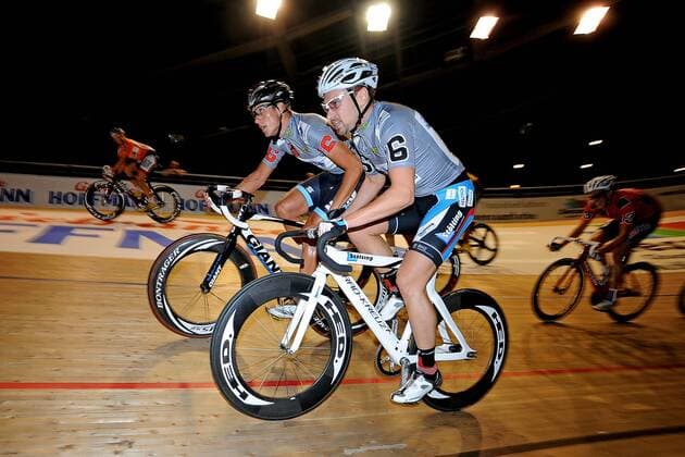 Björn SCHRÖDER ( unten DEU ) mit seinem Partner Guy EAST ( oben USA ) beim Wechsel - 30 Minuten Jagd - Paar Nr. 16 - Aktion - quer - Event: Berliner Sechstagerennen - Sixdays Berlin 2013 - Location: Velodrom Berlin - Deutschland - Europa - Datum: 24.01.2013