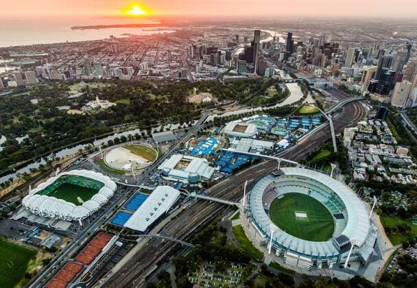 Australian Open 2013, Melbourne Park,ITF Grand Slam Tennis Tournament, Uebersicht aus der Luft,in der Mitte die Melbourne Park Tennis Anlage, rechts Melbourne Cricket Ground,links Fussball Stadion dahinter der Botanische Garten,der Yarra River und die Stadt,Sonnenuntergang, Querformat,