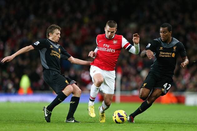 Football - 2012 2013 Premier League - Arsenal FC vs Liverpool FC Lukas Podolski of Arsenal under pressure from Liverpool s Andre Wisdom and Lucas Leiva at the Emirates Stadium, London 