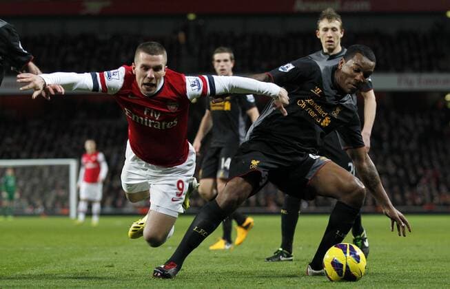 LONDON, Jan. 30, 2013 (Xinhua) -- Lukas Podolski (L) of Arsenal vies with Andre Wisdom of Liverpool during the Barclays Premier League match between Arsenal and Liverpool at Emirates Stadium on January 30, 2013. The match ended with a 2-2 draw.(Xinhua Wang Lili) FOR EDITORIAL USE ONLY. NOT FOR SALE FOR MARKETING OR ADVERTISING CAMPAIGNS. NO USE WITH UNAUTHORIZED AUDIO, VIDEO, DATA, FIXTURE LISTS, CLUB LEAGUE LOGOS OR LIVE SERVICES. ONLINE IN-MATCH USE LIMITED TO 45 IMAGES, NO VIDEO EMULATION. NO USE IN BETTING, GAMES OR SINGLE CLUB LEAGUE PLAYER PUBLICATIONS. BRITAIN-LONDON-SOCCER-PREMIER LEAGUE-ARSENAL VS LIVERPOOL 