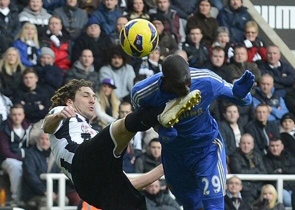 Demba Ba of Chelsea (R) gets a kick in the face from Fabricio Coloccini of Newcastle United - Barclays Premier League - Newcastle Utd vs Chelsea - St. James Park - Newcastle - 02 02 13 - Picture Richard Lee Sportimage EDITORIAL USE ONLY. No use with unauthorised audio, video, data, fixture lists, club league logos or live services. Online in-match use limited to 120 images, no video emulation. No use in betting, games or single club league player publications.