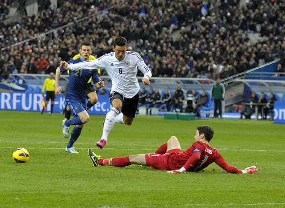 06.02.2013, Fussball Testländerspiel, Frankreich - Deutschland, im Stade de France in Paris (Frankreich). Mesut Özil (li, Deutschland) überspringt Torwart Hugo Lloris (FRA).