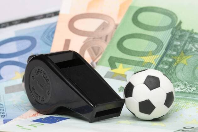 Wettskandal - Fußball liegt mit einer Schiedsrichter Pfeife auf Euro Geldscheinen