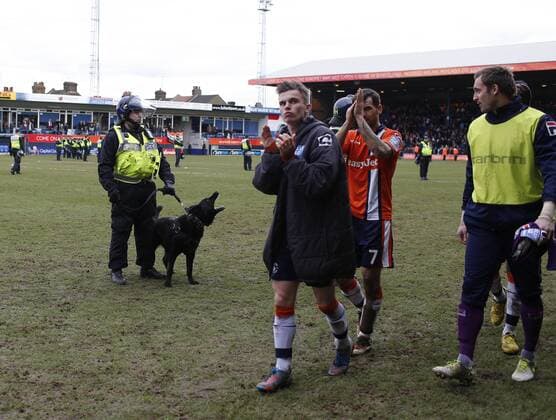 Luton s players trudge off at the final whistle as Police and their dogs look on..Luton Town FC vs. Millwall FC - FA Cup 5th Round - Kenilworth Road, Luton- 16 02 13 - EDITORIAL USE ONLY. No use with unauthorised audio, video, data, fixture lists, club league logos or live services. Online in-match use limited to 120 images, no video emulation. No use in betting, games or single club league player publications.