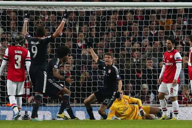 Football - 2012 2013 Champions League - Round of 16, First Leg: Arsenal vs. Bayern Munich Bayern Munich s Thomas Müller celebrates scoring while a dejected Mikel Arteta of Arsenal (right) looks on at the Emirates Stadium, London 