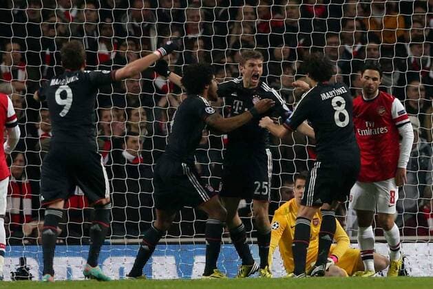 Football - 2012 2013 Champions League - Round of 16, First Leg: Arsenal vs. Bayern Munich Bayern Munich s Thomas Müller celebrates scoring while a dejected Mikel Arteta of Arsenal (right) at the Emirates Stadium, London 