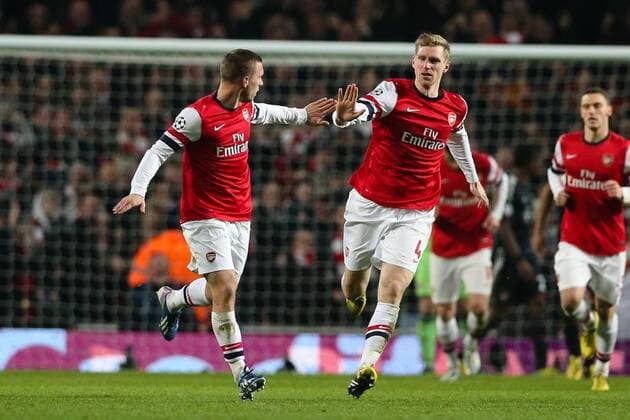 Football - 2012 2013 Champions League - Round of 16, First Leg: Arsenal vs. Bayern Munich Lukas Podolski of Arsenal celebrates scoring with Per Mertesacker of Arsenal at the Emirates Stadium, London 