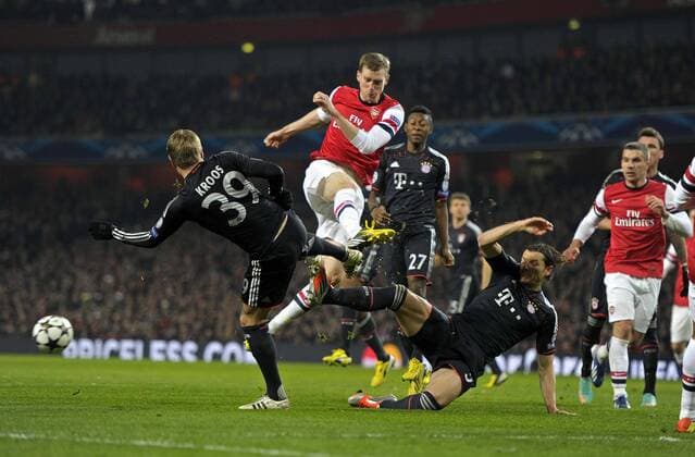 19.02.2013, Fussball Champions League: FC Arsenal London - FC Bayern München, im Emirates-Stadion London. v.li: Toni Kroos (Bayern München), Per Mertesacker (Arsenal) Daniel van Buyten (Bayern München).