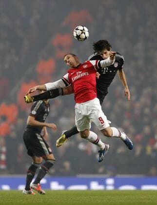 Arsenal s Lukas Podolski tussles with Munich s Javi Martinez..Arsenal v Bayern Munich - Champions League Second Round, First Leg- Emirates Stadium, London- 19 02 13 - Picture David Klein Sportimage EDITORIAL USE ONLY. No use with unauthorised audio, video, data, fixture lists, club league logos or live services. Online in-match use limited to 120 images, no video emulation. No use in betting, games or single club league player publications.