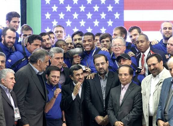 Iranian president Mahmoud Ahmadinejad (below C) stands beside members of the USA s freestyle wrestling team at the awarding ceremony of the Wrestling World Cup 2013 in Tehran, Iran, on Feb. 22, 2013. The team of the United States took the third place. (Xinhua Ahmad Halabisaz) IRAN-TEHRAN-WRESTLING-WORLD CUP 2013 