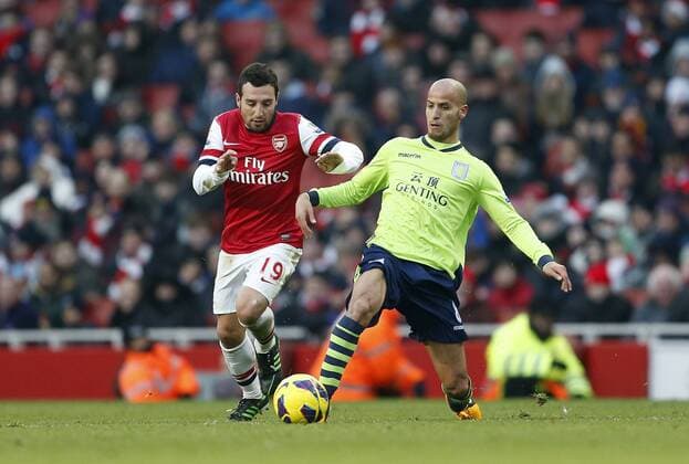 Arsenal FC London s Santi Cazorla tussles with Aston Villa s Karim El Ahmadi..Arsenal FC London v Aston Villa - Premier League - Emirates Stadium, London- 23 02 13 - EDITORIAL USE ONLY. No use with unauthorised audio, video, data, fixture lists, club league logos or live services. Online in-match use limited to 120 images, no video emulation. No use in betting, games or single club league player publications.