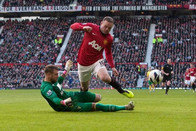 Football - 2012 2013 Premier League - Manchester United (ManU) vs. Norwich City - Mark Bunn of Norwich challenges Wayne Rooney of Manchester United (ManU) at Old Trafford 