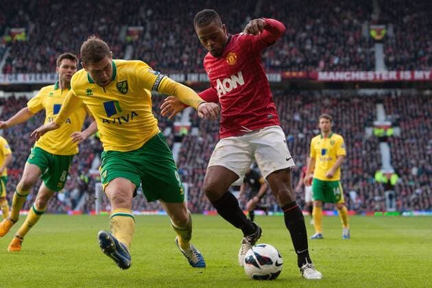 Football - 2012 2013 Premier League - Manchester United (ManU) vs. Norwich City - Norwich s Grant Holt and Patrice Evra of Manchester United (ManU) at Old Trafford 