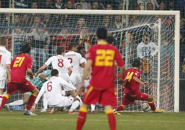 Montenegro s Dejan Damjanovic scoring his sides opening goal..Montenegro v England- World Cup Qualifier - Podgorica City Stadium, Podgorica- 26 03 13 - Picture David Klein Sportimage EDITORIAL USE ONLY. No use with unauthorised audio, video, data, fixture lists, club league logos or live services. Online in-match use limited to 120 images, no video emulation. No use in betting, games or single club league player publications.