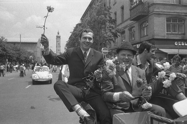 Franz BECKENBAUER winkt mit einer Nelke aus dem Cabrio, jubelt, re. August -Gustl- Starek - Die Spieler des FC Bayern München fahren im Autokorso durch die Münchener Innenstadt, Cabrio, VW Käfer, jubeln zu den Passanten, präsentieren den Pokal