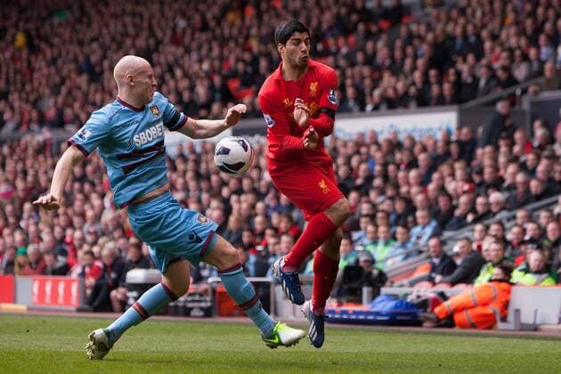 Football - 2012 2013 Premier League. Liverpool FC - West Ham United, West Ham s James Collins clears the ball from Luis Suarez of Liverpool at Anfield 
