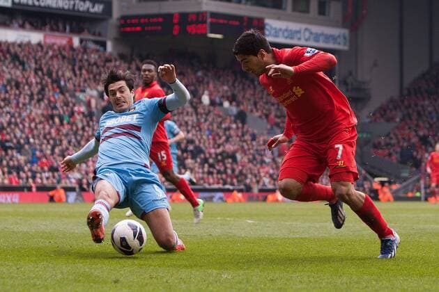 Football - 2012 2013 Premier League. Liverpool FC - West Ham United, West Ham s James Tomkins clears the ball from an advancing Luis Suarez of Liverpool at Anfield 