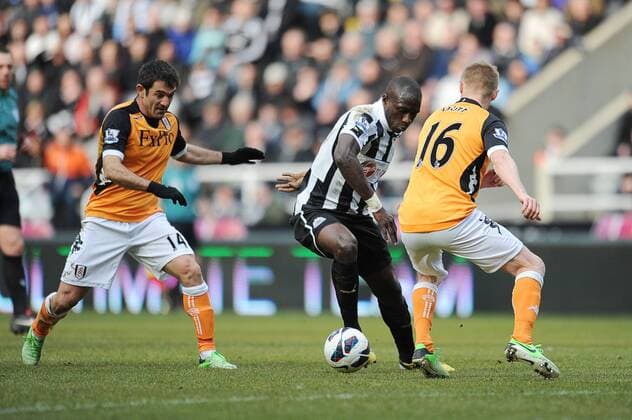 Football - Premier League - Newcastle United vs. FC Fulham: Moussa Sissoko (Newcastle United) goes in-between Damien Duff and Giorgos Karagounis (Fulham) at St James Park. 
