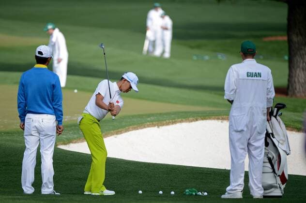 Guan Tianlang of China chips on the practice range during a practice round before the Master golf tournament at Augusta National Golf Club on April 8, 2013 in Augusta, Georgia. Tianlang, the Asia-Pacific Amateur Champion, will be the youngest starter in Masters history at 14-years-old.  AUG20130408302