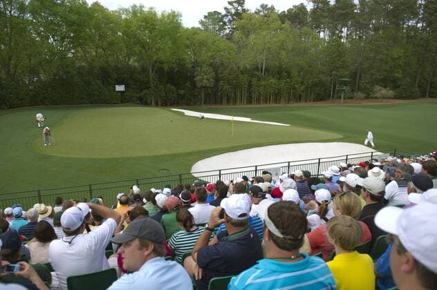 Patrons watch as Tiger Woods putts on the 3rd green during a practice round before the Master golf tournament at Augusta National Golf Club on April 9, 2013 in Augusta, Georgia.  AUG20130409358