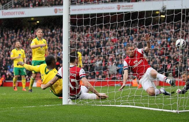 Norwich s Sebastian Bassong scoring an own goal to put Arsenal 2-1 up.. FC Arsenal London vs Norwich City - Barclays Premier League - Emirates Stadium, London- 12 04 13 - EDITORIAL USE ONLY. No use with unauthorised audio, video, data, fixture lists, club league logos or live services. Online in-match use limited to 120 images, no video emulation. No use in betting, games or single club league player publications.