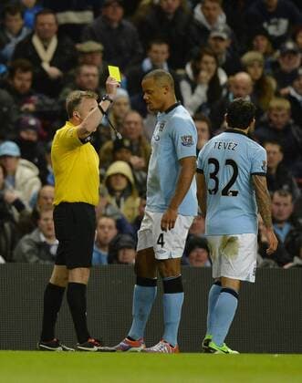 Yellow card for Carlos Tevez of Manchester City - Barclays Premier League - Manchester City vs Wigan Athletic - EDITORIAL USE ONLY. No use with unauthorised audio, video, data, fixture lists, club league logos or live services. Online in-match use limited to 120 images, no video emulation. No use in betting, games or single club league player publications.