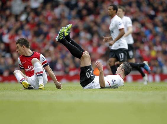 Robin van Persie on the floor following a tackle by Laurent Koscielny of FC Arsenal - Barclays Premier League - FC Arsenal vs Manchester United (ManU) - Emirates Stadium London - Season 12 13 - 28th April 2013 - EDITORIAL USE ONLY. No use with unauthorised audio, video, data, fixture lists, club league logos or live services. Online in-match use limited to 120 images, no video emulation. No use in betting, games or single club league player publications.