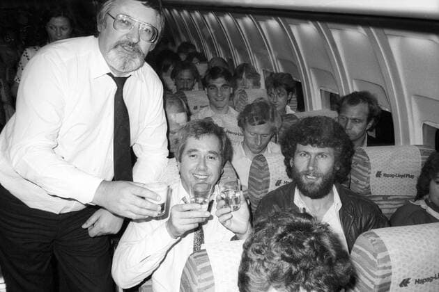 Der FC Bayern München ist DFB Pokalsieger 1982 - Auf dem Rückflug feiern Präsident Willi O. Hoffmann, Fritz Scherer und Paul Breitner mit Sekt, dahinter Bernd Dürnberger, Uli Hoeneß, Walter Junghans und Hans Weiner