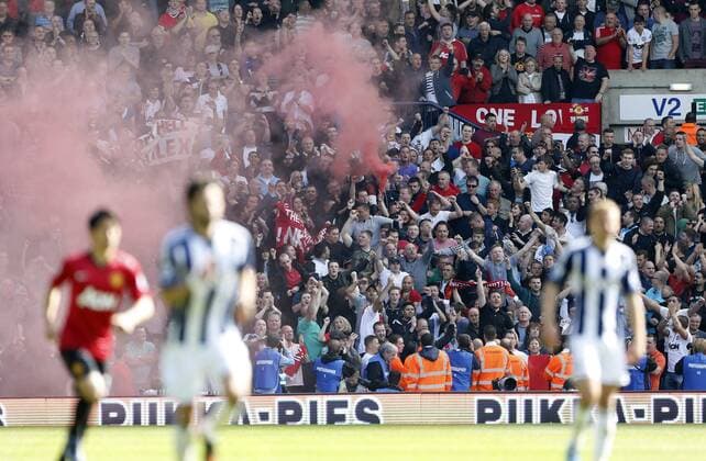 Manchester United s fans let off a smoke bomb - Barclays Premier League - Manchester United - The Hawthrowns - West Bromwich - 19 05 2013 - Pic David Klein Sportimage EDITORIAL USE ONLY. No use with unauthorised audio, video, data, fixture lists, club league logos or live services. Online in-match use limited to 120 images, no video emulation. No use in betting, games or single club league player publications.