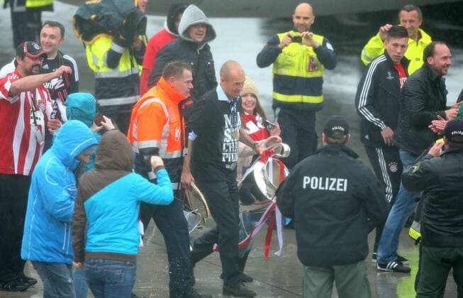 26.05.2013, Fussball Ankunft des UEFA Champions League Sieger 2013 FC Bayern München am Flughafen München. Arjen Robben (mi., Bayern München) mit Pokal