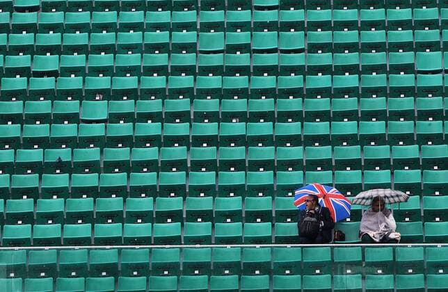 (130530) -- PARIS, May 30, 2013 (Xinhua) -- Spectators sit on the centre court as rain falls during the 2013 French Open tennis tournament at Roland Garros in Paris, France on May 30, 2013. (Xinhua Gao Jing) (hcs) (SP)FRANCE-PARIS-TENNIS-FRENCH OPEN 