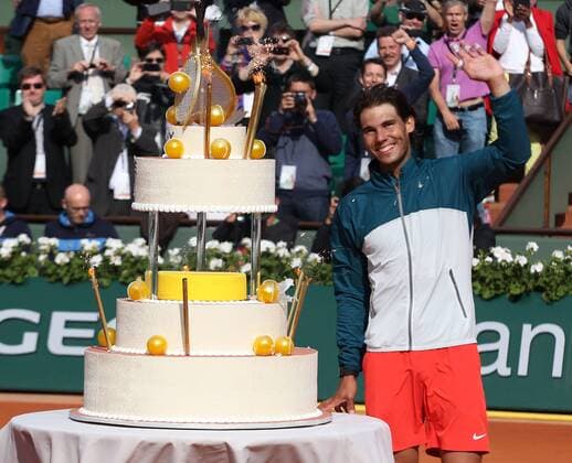 French Open 2013, Roland Garros,Paris,ITF Grand Slam Tennis Tournament, Rafael Nadal (ESP) mit einer riesigen Geburtstagstorte auf dem Centre Court, Einzelbild,Halbkoerper,Querformat,