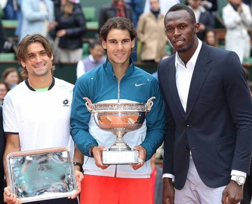 David Ferrer (L) and Rafael Nadal (C) hold their trophies next to Usain Bolt after Nadal won their French Open men s final match at Roland Garros in Paris on June 9, 2013. Nadal become the first player ever to win the same Grand Slam tournament eight times.  PAR20130609751