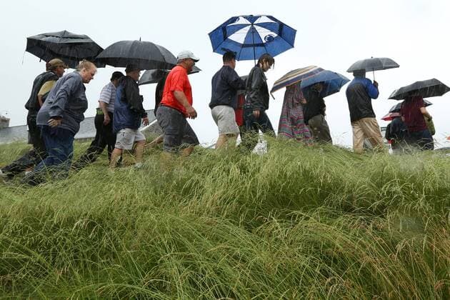 June 10 2013: Droves of fans with umbrellas walk over a path through the thicket to get out of the driving rain during monday s practice round at the 2013 U.S. Open hosted by Merion Golf Club in Ardmore, PA. GOLF: JUN 10 PGA Golf Herren - U.S. Open - Monday Practice Round Icon131834 EDITORIAL USE ONLY
