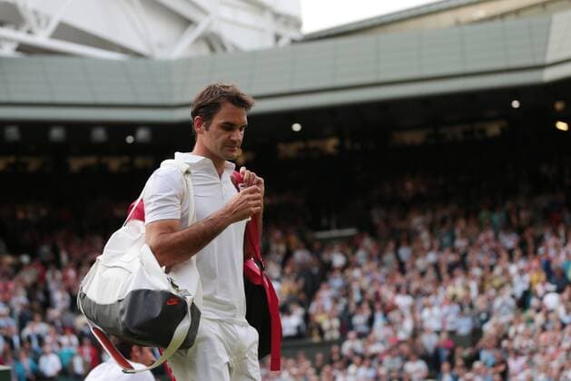 Roger Federer leaves Center Court after being defeated by Ukranian Sergiy Sakhovsky on day three of the 2013 Wimbledon Championships in London on June 26, 2013.  LON2013062626