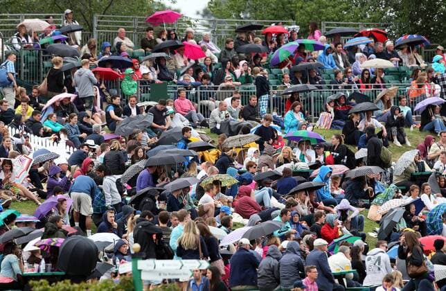 Tennis funs huddle under their umbrellas on Henman Hill as rain stopped play for the first time this year at the Wimbledon Tennis Championships, Thursday, 27th June 2013 Picture by Stephen Lock i-Images StephenxLockx xi-Images  IIM-0153-0035