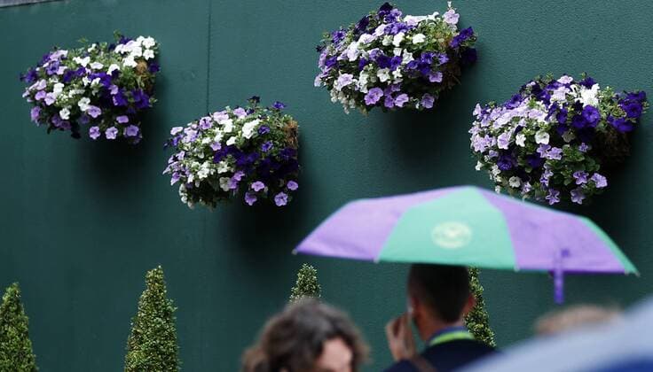 LONDON, June 28, 2013 - A journalist holding an umbrella makes a call at the entrance of the press center on day 5 of the Wimbledon Lawn Tennis Championships at the All England Lawn Tennis and Croquet Club in London, Britain, on June 28, 2013. (Xinhua Wang Lili) BRITAIN-LONDON-TENNIS-WIMBLEDON-DAY 5 
