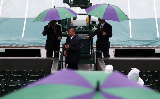 LONDON, June 28, 2013 - Stewards holding umbrellas wait at No.1 Court on day 5 of the Wimbledon Lawn Tennis Championships at the All England Lawn Tennis and Croquet Club in London, Britain, on June 28, 2013. (Xinhua Wang Lili) BRITAIN-LONDON-TENNIS-WIMBLEDON-DAY 5 