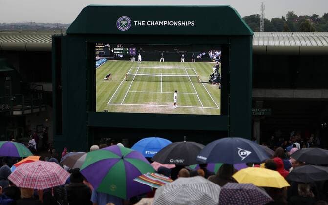 LONDON, June 28, 2013 - Spectators hold umbrellas in the rain to watch the third round match of gentlemen s singles between Andy Murray of Great Britain and Tommy Robredo of Spain at Henman Hill on day 5 of the Wimbledon Lawn Tennis Championships at the All England Lawn Tennis and Croquet Club in London, Britain, on June 28, 2013. (Xinhua Wang Lili) BRITAIN-LONDON-TENNIS-WIMBLEDON-DAY 5 