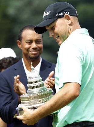 Bill Haas holds his trophy next to Tiger Woods after winning the AT&T National at Congressional Country Club on June 30, 2013 in Bethesda, Maryland.  WAP20130630839