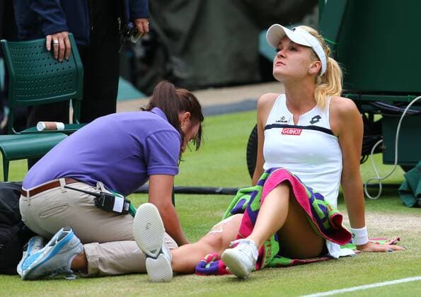 LONDON, July 2, 2013 -- Agnieszka Radwanska (R) of Poland receives the medical treatment during the quarterfinal of women s singles on day 8 of the Wimbledon Lawn Tennis Championships at the All England Lawn Tennis and Croquet Club in London, Britain on July 2, 2013. 