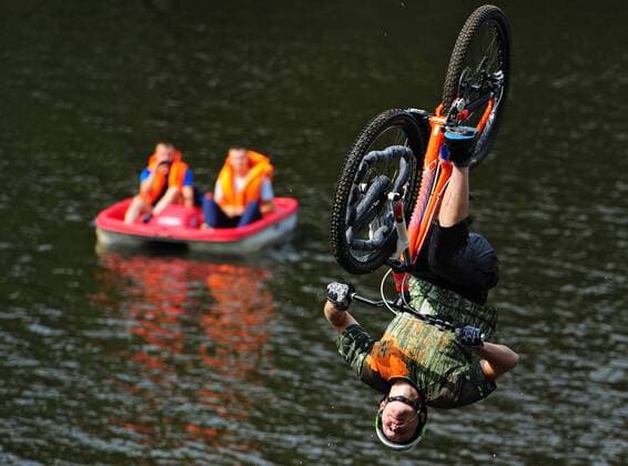 ITAR-TASS: IVANOVO, RUSSIA. AUGUST 5, 2013. Competitors perform stunts as they jump into the water off a ramp in Fun Jumping, a bike jumping event in the city of Ivanovo.  RE124604