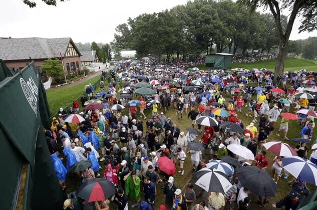 Spectators walk the grounds carrying umbrellas in the rain in the second round of the PGA Golf Herren Championship at Oak Hill Country Club in Rochester, New York on August 9, 2013.  NYP20130809122