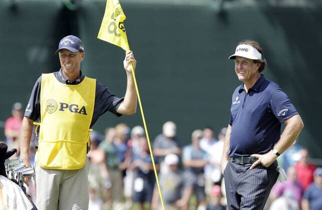 Phil Mickelson and caddie Jim Bones MacKay stand on the 18th green in the final round of the PGA Golf Herren Championship at Oak Hill Country Club in Rochester, New York on August 11, 2013.  NYP20130811102
