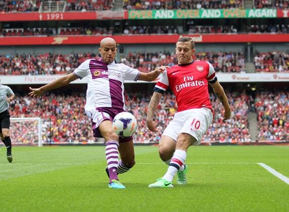 Arsenal s Jack Wilshere tussles with Villa s Karim El Ahmadi - FC Arsenal London v Aston Villa FC - Barclays Premiership - Emirates Stadium - London - England -17 08 2013 - EDITORIAL USE ONLY. No use with unauthorised audio, video, data, fixture lists, club league logos or live services. Online in-match use limited to 120 images, no video emulation. No use in betting, games or single club league player publications.